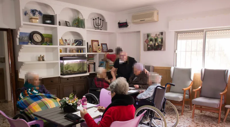 Taller de actividades en el salón: residentes acompañados por una profesional de Fuenteclara
